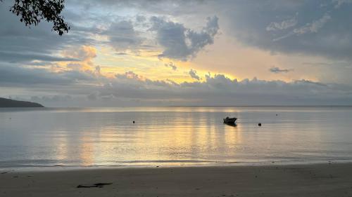 um barco sentado na água em uma praia em Marema Pousada na Ilha do Mel