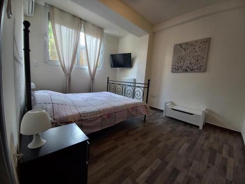 a bedroom with a bed and a television in it at Modern and Cosy Apartment in Athens