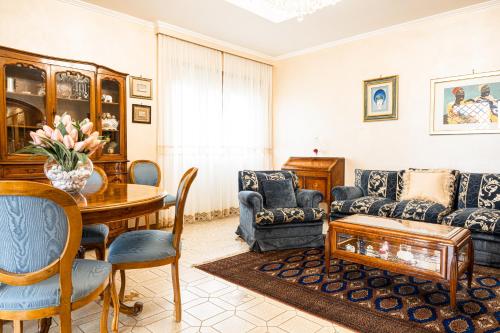 ein Wohnzimmer mit einem Tisch, Stühlen und einem Sofa in der Unterkunft Quinto Piano in Rom