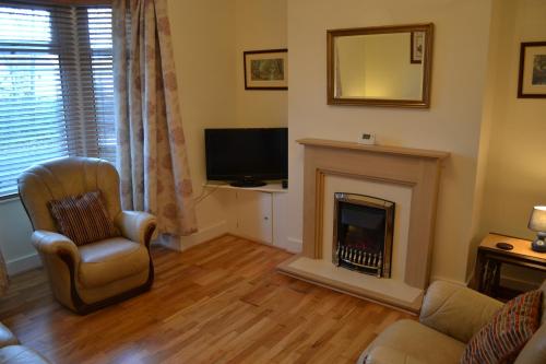 a living room with a fireplace and a television at Entire 3 bedroom house near Caerphilly station in Caerphilly