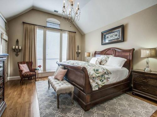 a bedroom with a large bed and a chair at Executive home w/Study + pool near Lake in Rockwall