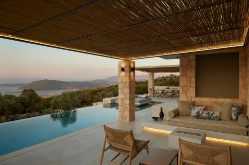 a villa with a swimming pool and a living room at Epiphany Villas Lefkada in Tsoukaladhes