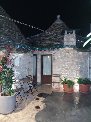a patio with a table and chairs and plants at Trulli Resort Grassi in Alberobello