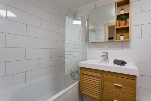 uma casa de banho com um lavatório e um chuveiro em Chalet Grand Balcon em Les Houches