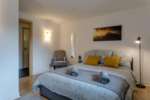Un dormitorio con una cama grande con almohadas amarillas. en Chalet Grand Balcon, en Les Houches