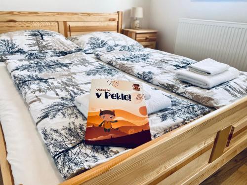 a bedroom with a bed with a book on it at Hotel Peklo pro rodiny s dětmi in Josefŭv Dŭl