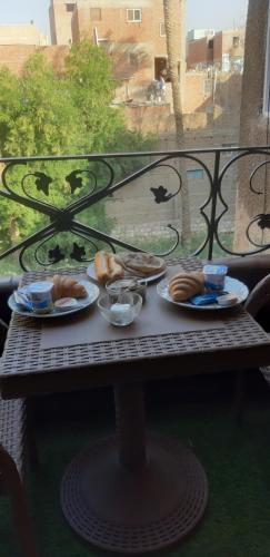 a table with plates of food on a balcony at Bella Casa Pyramids Inn in Cairo