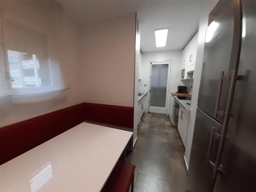 una pequeña cocina con un banco en una habitación en Los Sauces III, en Jaca