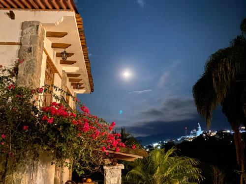 a view of a building with pink flowers and the moon at Hotel Posada La Vereda in Cuetzalán del Progreso
