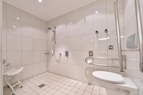 La salle de bains est pourvue d'une douche, de toilettes et d'un lavabo. dans l'établissement STADT HOTEL Iserlohn, à Iserlohn