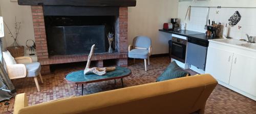 sala de estar con sofá y chimenea en L'auberge 10 à 15 pers 30min zoo beauval chambord cheverny en Langon