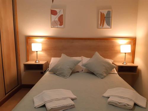 a bedroom with two towels on a bed with two lamps at Departamento Las Margaritas in Potrero de los Funes