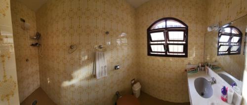 a bathroom with a sink and a toilet and a window at Linda Casa com Piscina - Praia do Pernambuco - Guarujá in Guarujá