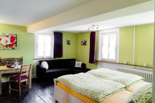 NohenにあるAllerHand Gästezimmer Nohenの緑の壁のベッドルーム(ベッド1台、テーブル付)