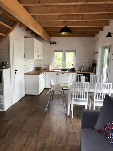 a kitchen and living room with a table and chairs at Joniec Świata - 2 domy na wyłączność in Joniec