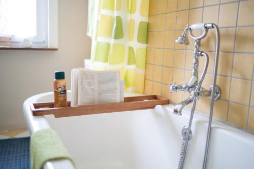 a bath tub with a shower in a bathroom at AllerHand Gästezimmer Nohen in Nohen