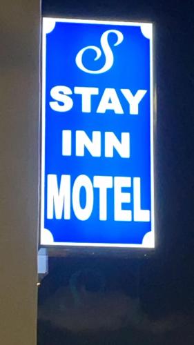 um sinal que diz fiquem motel on a wall em Stay Inn Motel em Harbor City