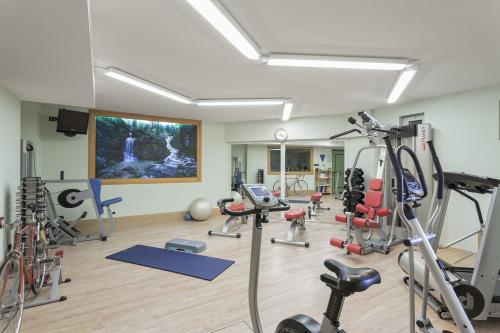 un gimnasio con muchos equipos de ejercicio en una habitación en Hotel Chalet Del Sogno en Madonna di Campiglio