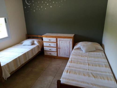 1 dormitorio con 2 camas y tocador de madera en departamento chateau en Córdoba