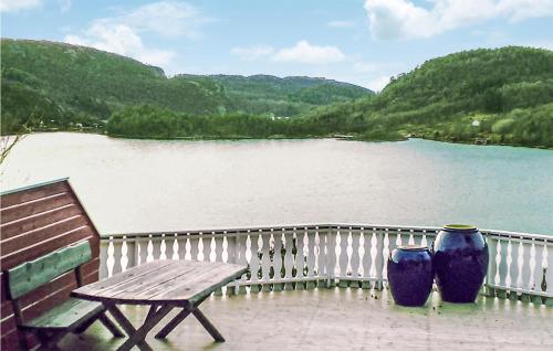 two blue vases sitting next to a bench and a lake at Holiday Home Lyngdal Bordvik in Belland