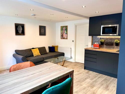 a living room with a couch and a table at Smart/ Modern one bedroom flat in Purley