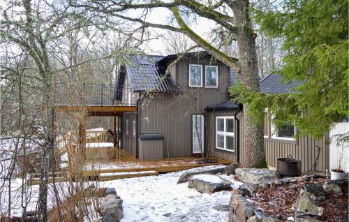 a small house with a deck in the snow at Cozy Home In Strängnäs With Sauna in Strängnäs