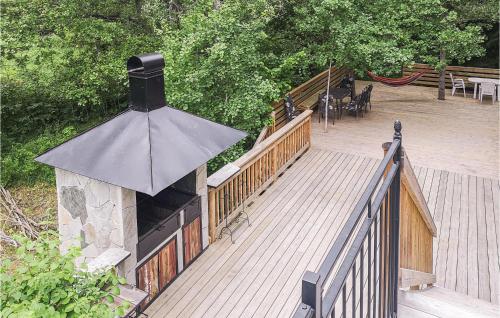 an outdoor deck with a grill and a wooden railing at Cozy Home In Strängnäs With Sauna in Strängnäs