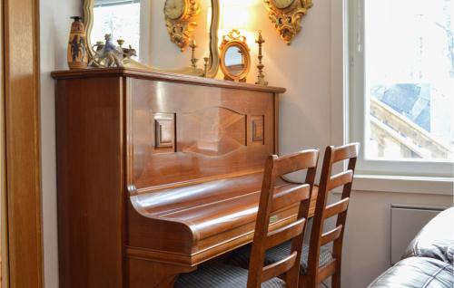 a wooden dresser with a mirror and two chairs at Cozy Home In Strängnäs With Sauna in Strängnäs