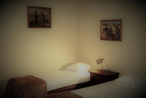 a bedroom with two beds and a table with a lamp at Hoeve de Mertel in Biezenmortel