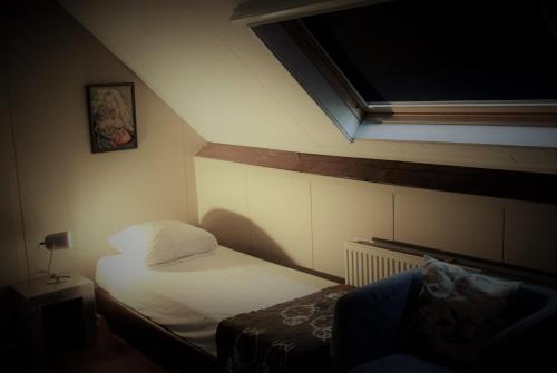 a small room with a bed and a window at Hoeve de Mertel in Biezenmortel