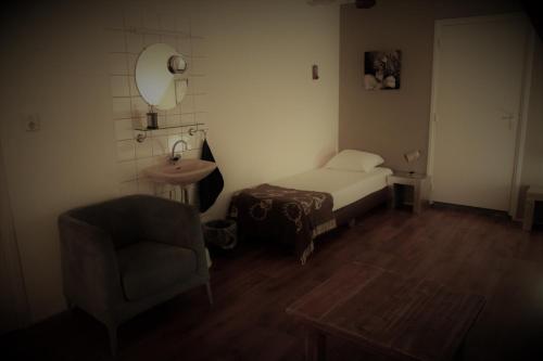 a bedroom with a bed and a chair and a mirror at Hoeve de Mertel in Biezenmortel