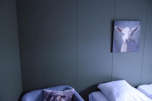 a bedroom with a picture of a goat on the wall at Hoeve de Mertel in Biezenmortel