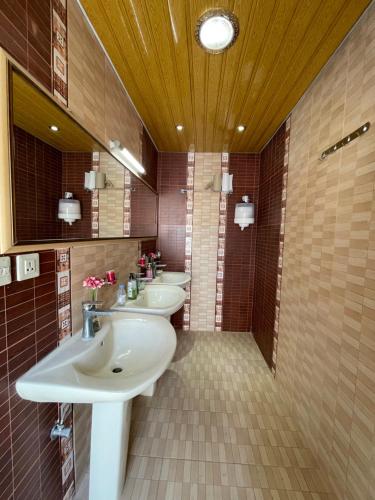La salle de bains est pourvue de 2 lavabos et de 2 miroirs. dans l'établissement منتجع اكواخ النخيل, à Al Muţayrifī