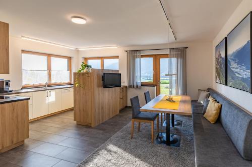 a kitchen and living room with a table and a couch at Apartment Hohe Munde in Inzing