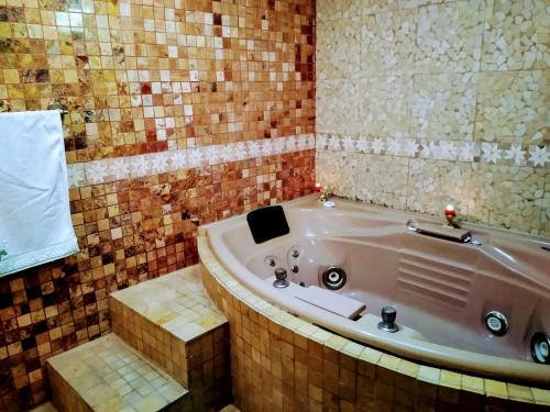 Habitación matrimonial con cama y sofá para cuatro personas في Tlazcalancingo: حمام مع حوض استحمام في الغرفة