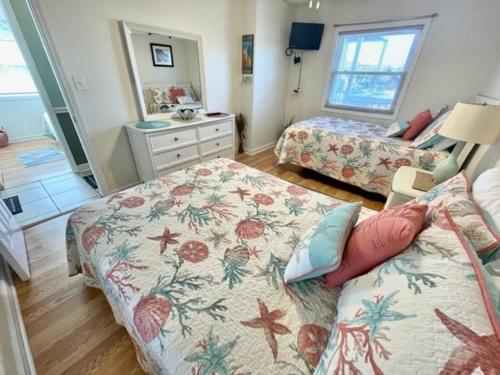 a bedroom with two beds and a mirror at Boston Commons 101 Condo in Myrtle Beach