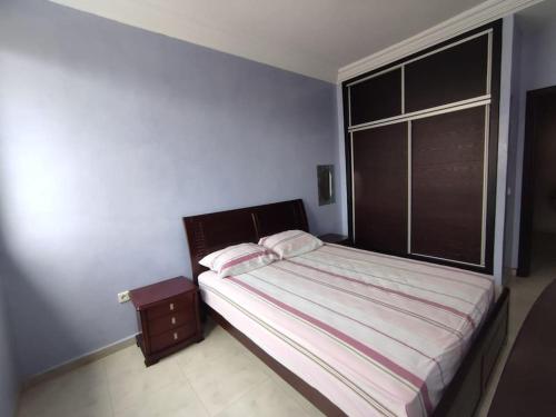 a bedroom with a bed and a large window at Appartement Casablanca Anfa in Casablanca