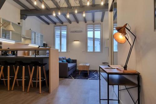 un salon et une cuisine avec un canapé et une table dans l'établissement Appartement climatisé entièrement rénové en hyper centre! Le Rétro Chic - Parking gratuit - Linge et serviettes inclus -, à La Roche-Chalais