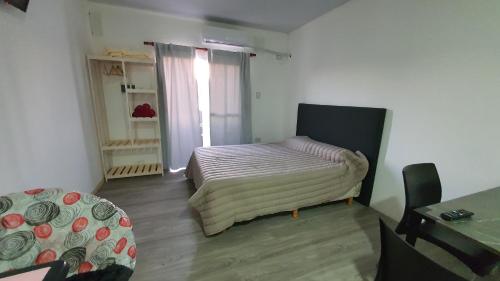 Dormitorio pequeño con cama y mesa en Las Golondrinas en Concepción del Uruguay