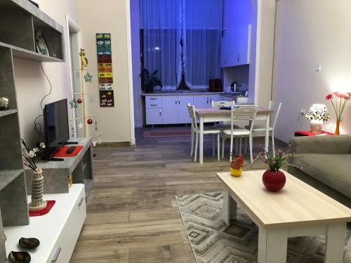 a living room with a table and a kitchen at Ani Apartament in Durrës