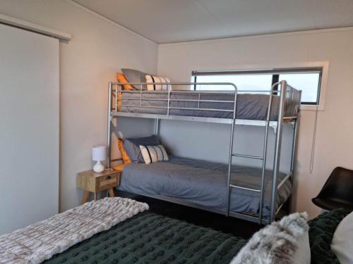 a bedroom with two bunk beds and a window at Mangorei Heights - New Plymouth in New Plymouth
