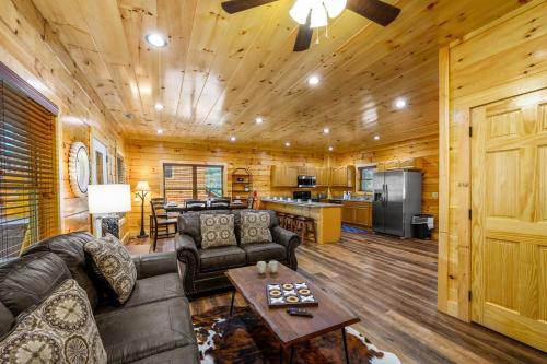 a living room with a couch and a table at 5Bd5B Escape Cabin with 2 HotTubs, Thtr &Game Rm,1mi to the Parkway! 4mi to Dollywood - Spring Deal in Pigeon Forge