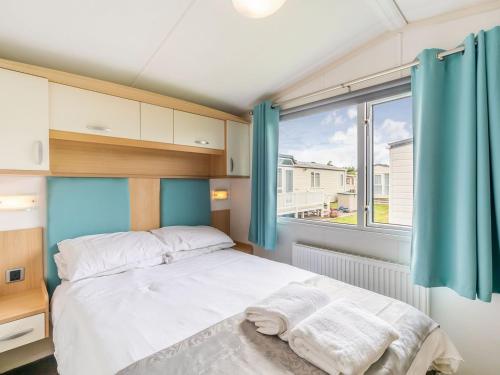 1 dormitorio con cama y ventana grande en Apple Tree Lodge, en Swarland