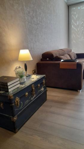 a room with a bed and a trunk with a lamp at Quinta Manuela in Mendoza
