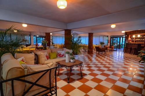 a living room with couches and a checkered floor at Hotel Rancho Constanza & Cabañas de la Montaña in Constanza