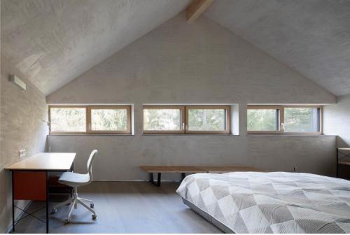 Schlafzimmer mit einem Bett, einem Schreibtisch und Fenstern in der Unterkunft Chalet Dachstein in Ramsau am Dachstein