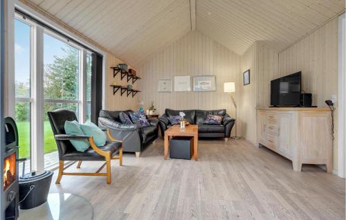 a living room with couches and a tv and a table at Cozy Home In Løgstør With Kitchen in Løgstør