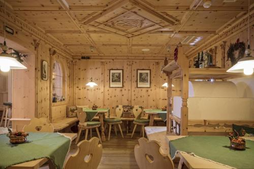 a restaurant with wooden walls and tables and chairs at Hotel Chalet Del Sogno in Madonna di Campiglio