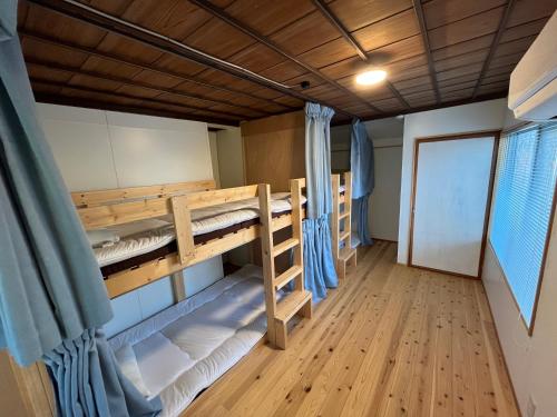 a room with bunk beds in a boat at Guesthouse Matsushiro Walkers in Nagano