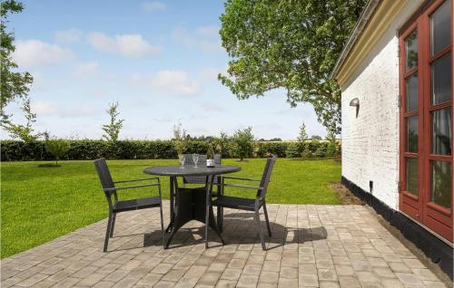 a table and chairs on a patio in a yard at Stunning Home In Bandholm With Kitchen in Bandholm